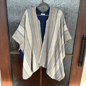 Jesse Kamm warming cape in a blue neutral stripe. One size
